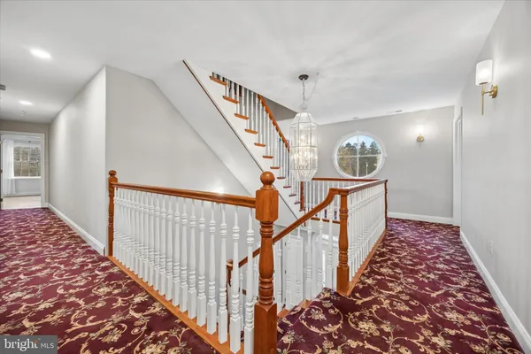 a view of a hallway with wooden floor and stairs
