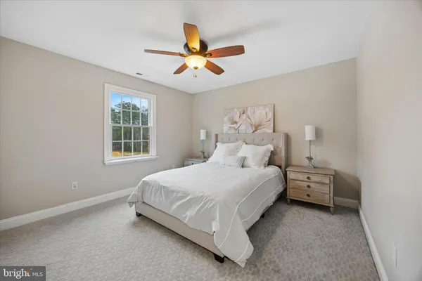 a bedroom with a bed and a ceiling fan