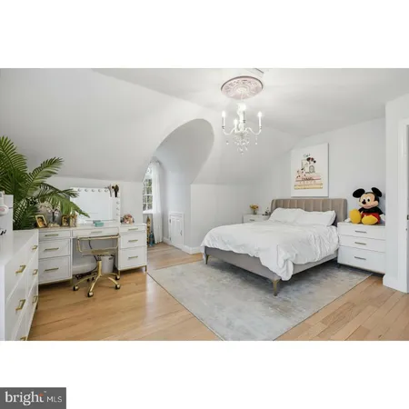 a bedroom with a bed a table and potted plants