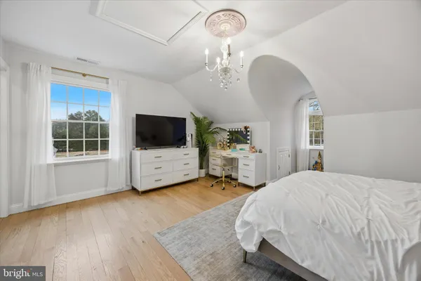 a spacious bedroom with a bed and a flat screen tv