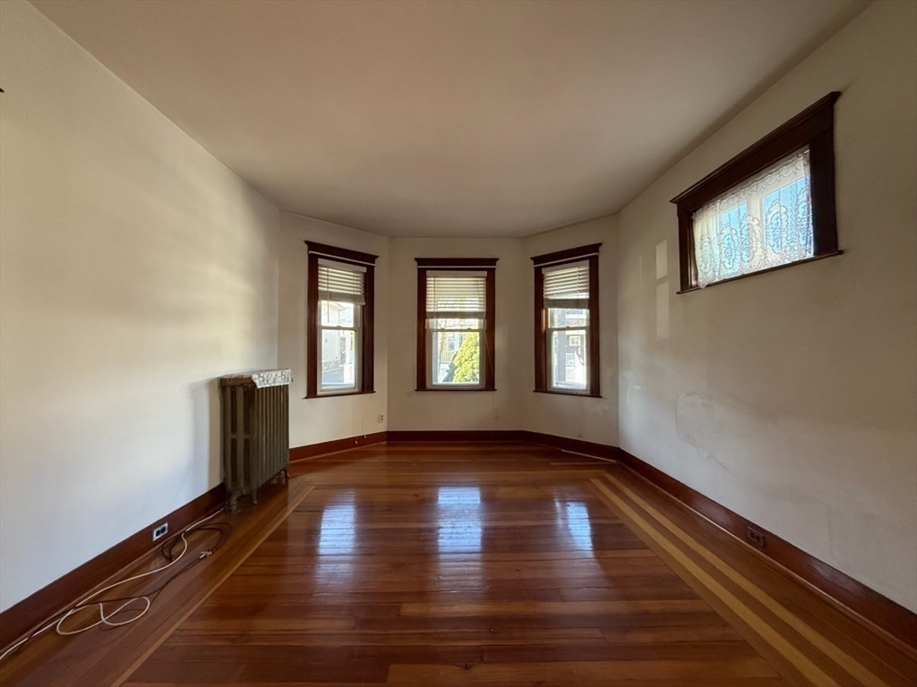 55-57 Evans Street Medford, MA 02155 - Photo 11 of 40 a view of an empty room with wooden floor and a window
