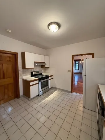 a kitchen with granite countertop a refrigerator and cabinets