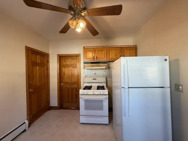 a kitchen with a refrigerator a stove top oven and cabinets