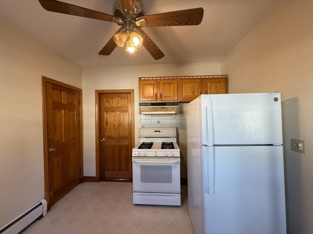 55-57 Evans Street Medford, MA 02155 - Photo 17 of 40 a kitchen with a refrigerator a stove top oven and cabinets