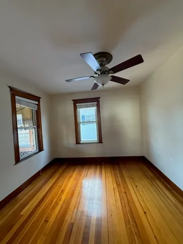 a view of an empty room window and wooden floor