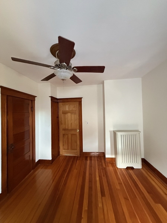 55-57 Evans Street Medford, MA 02155 - Photo 24 of 40 a view of a livingroom with wooden floor and a ceiling fan