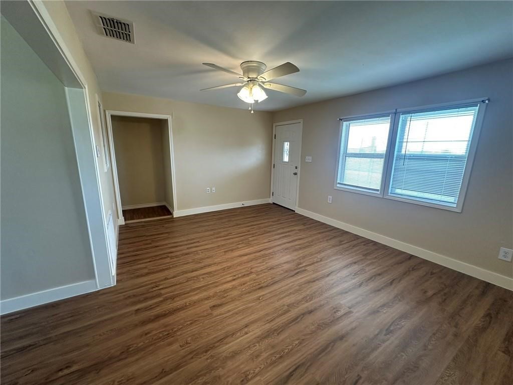 104 2nd Street Gregory, TX 78374 - Photo 2 of 27 a view of an empty room with wooden floor and a window