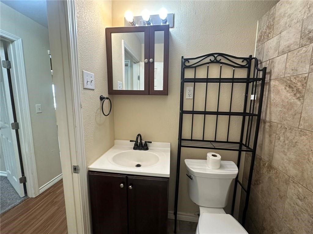 104 2nd Street Gregory, TX 78374 - Photo 22 of 27 a bathroom with a toilet sink and mirror