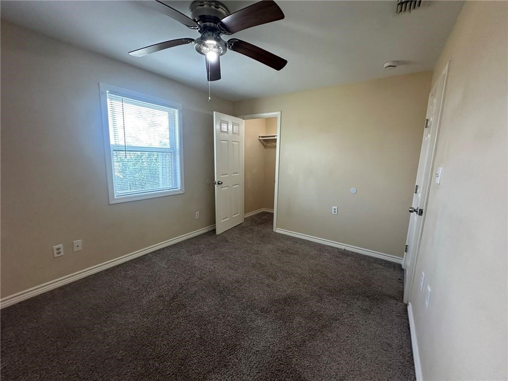 104 2nd Street Gregory, TX 78374 - Photo 25 of 27 en empty room with windows and chandelier fan