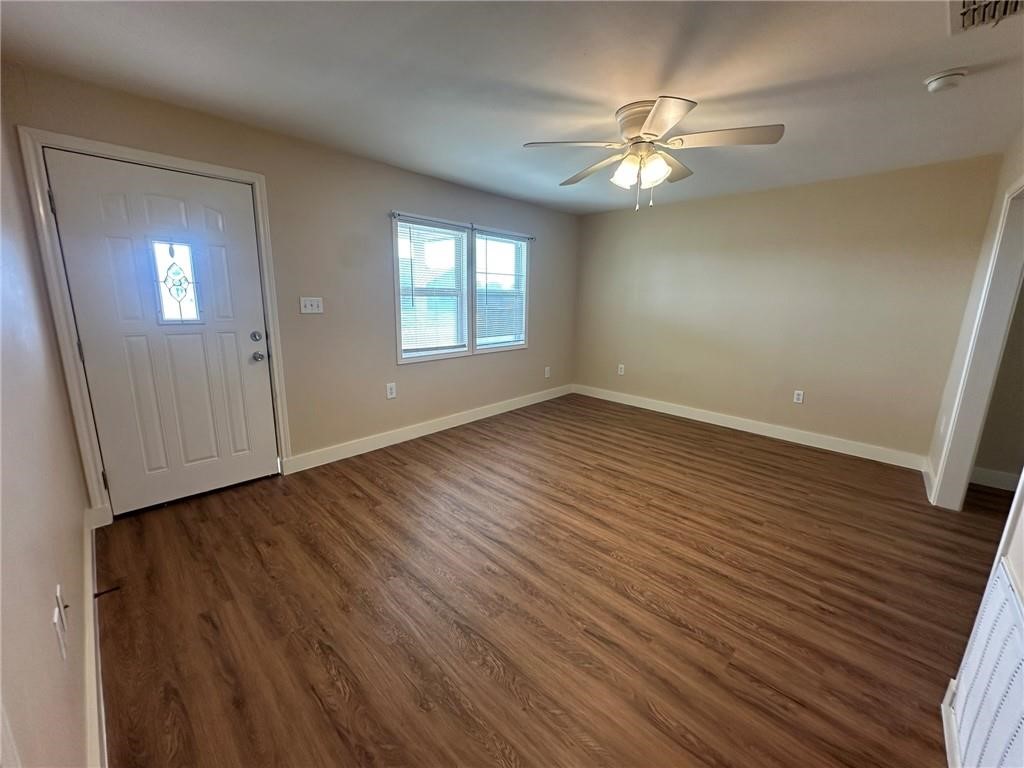 104 2nd Street Gregory, TX 78374 - Photo 4 of 27 a view of an empty room with wooden floor and a window