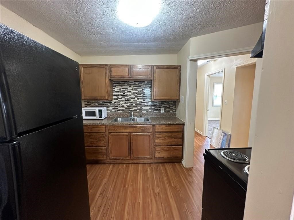 104 2nd Street Gregory, TX 78374 - Photo 5 of 27 a kitchen with a refrigerator and a stove