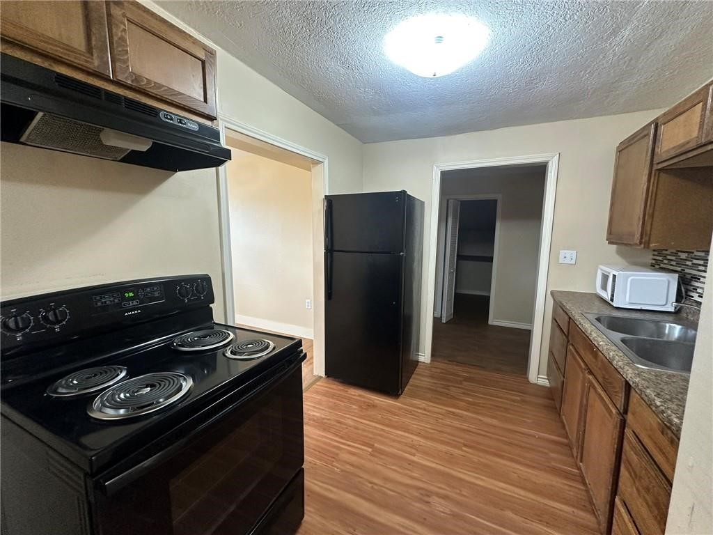 104 2nd Street Gregory, TX 78374 - Photo 6 of 27 a kitchen with a stove and a refrigerator