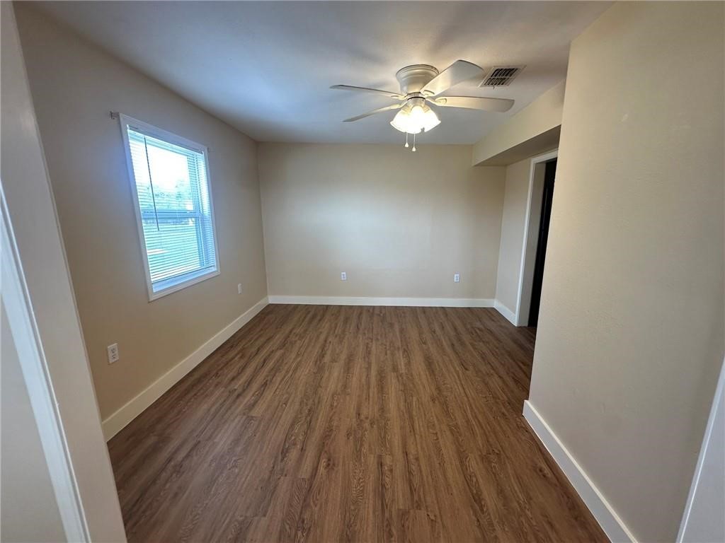 104 2nd Street Gregory, TX 78374 - Photo 7 of 27 wooden floor in an empty room with a mirror