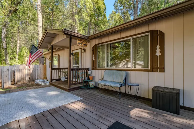 a view of a house with wooden deck and furniture