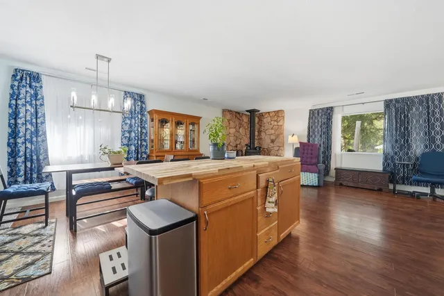 a room with kitchen island a stove a wooden floor and a window