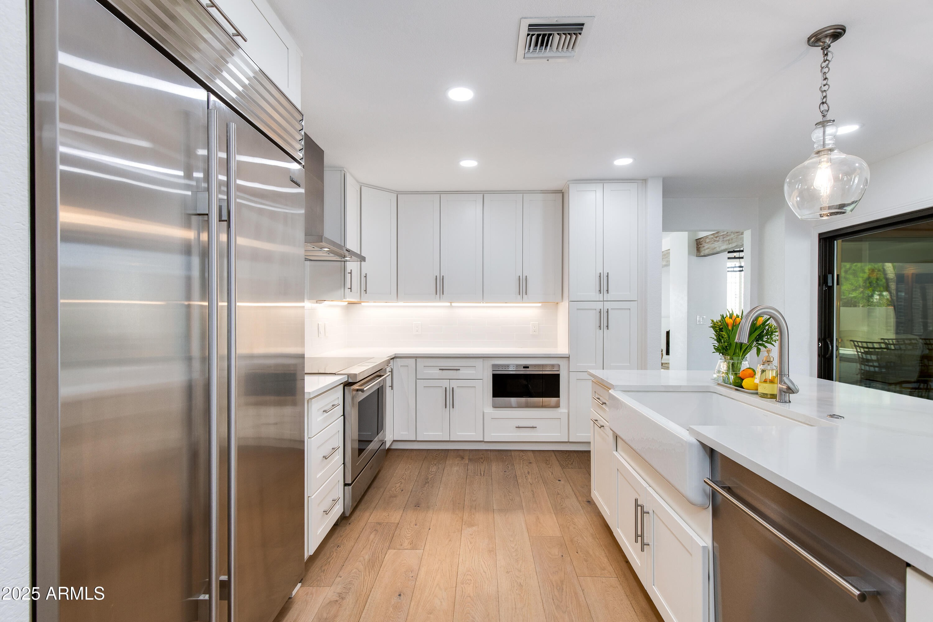 3116 East Rose Lane Phoenix, AZ 85016 - Photo 7 of 24 a kitchen with a sink stainless steel appliances and white cabinets