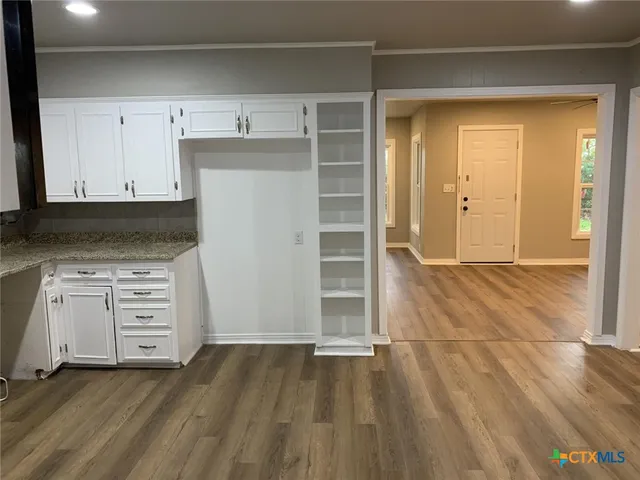 an empty room with cabinet and mirrors