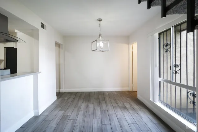 a view of a room with wooden floor staircase and a living room