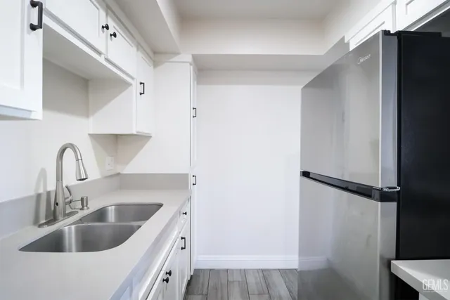 a kitchen with a refrigerator sink and cabinets