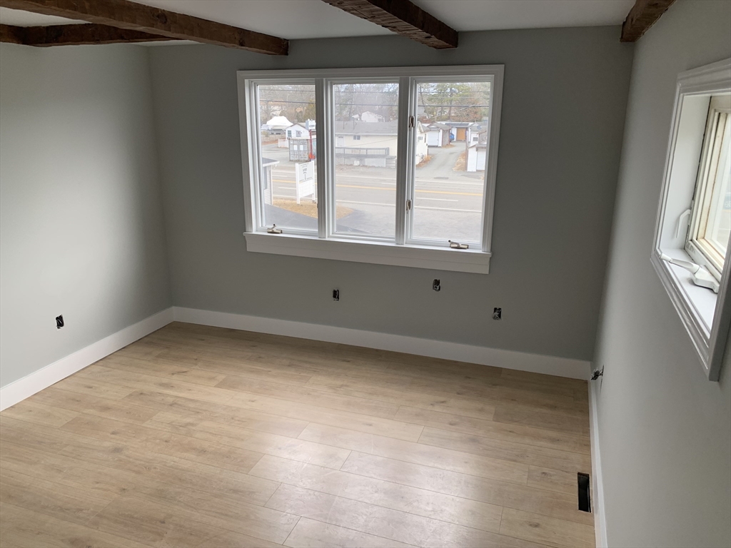 3161 Cranberry Highway, Unit 2 Wareham, MA 02538 - Photo 3 of 9 a view of an empty room with wooden floor and a window
