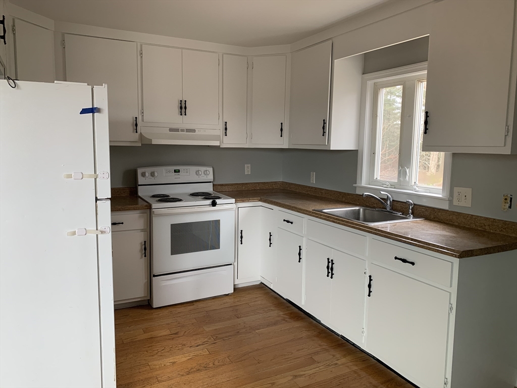 3161 Cranberry Highway, Unit 2 Wareham, MA 02538 - Photo 7 of 9 a kitchen with granite countertop white cabinets and white appliances