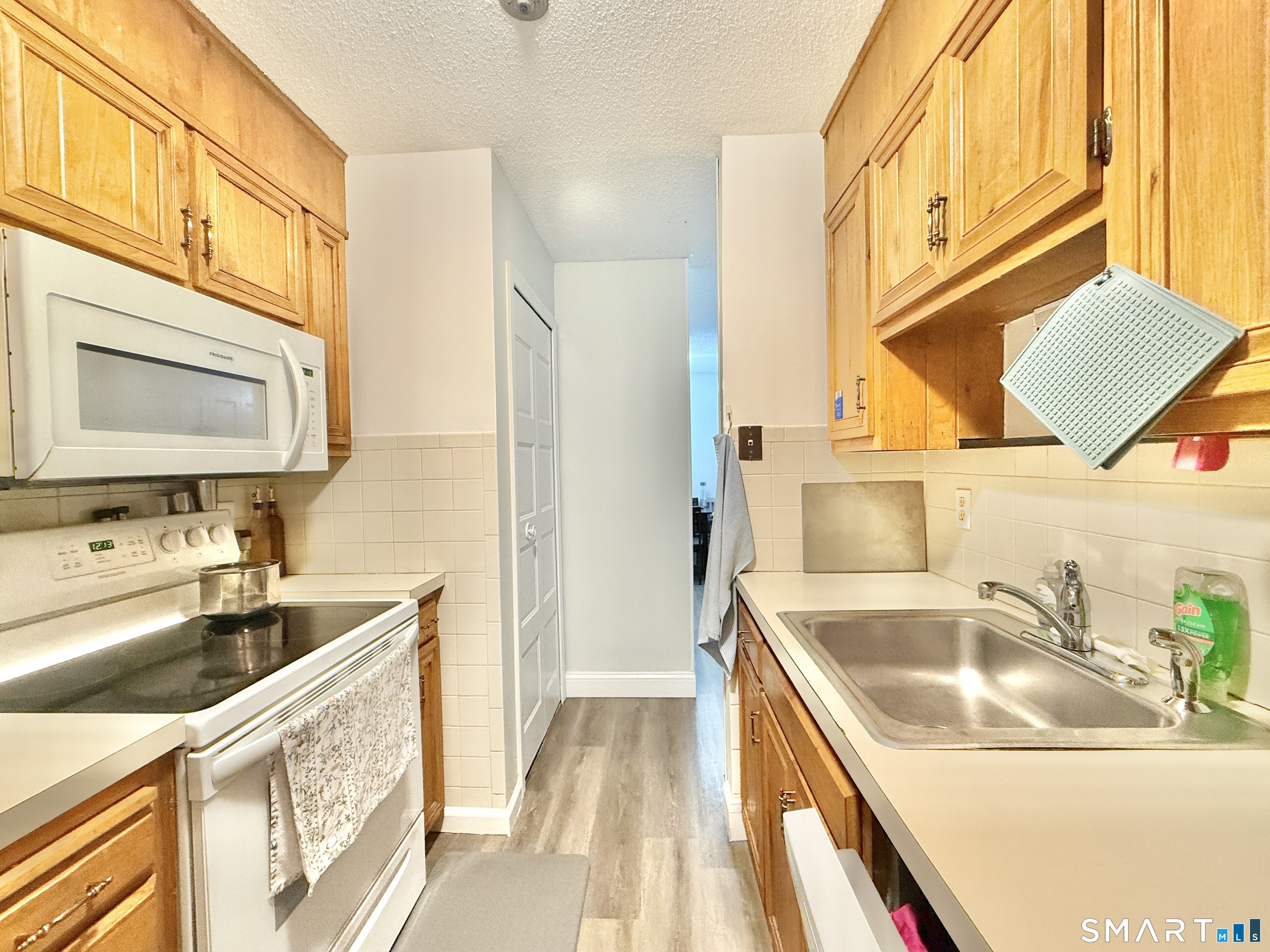 34 A Padanaram Road, Unit 127 Danbury, CT 06811 - Photo 3 of 13 a kitchen with a sink a stove and a microwave oven next to a window