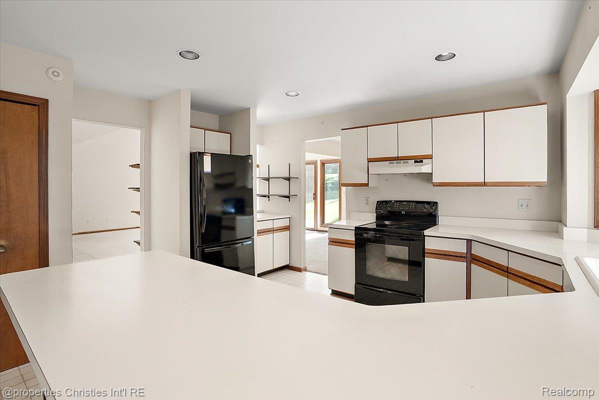 37224 Chesapeake Road Farmington, MI 48335 - Photo 30 of 50 Spacious kitchen featuring an extended peninsula, white cabinetry with wood trim accents, light-toned countertops, and recessed lighting