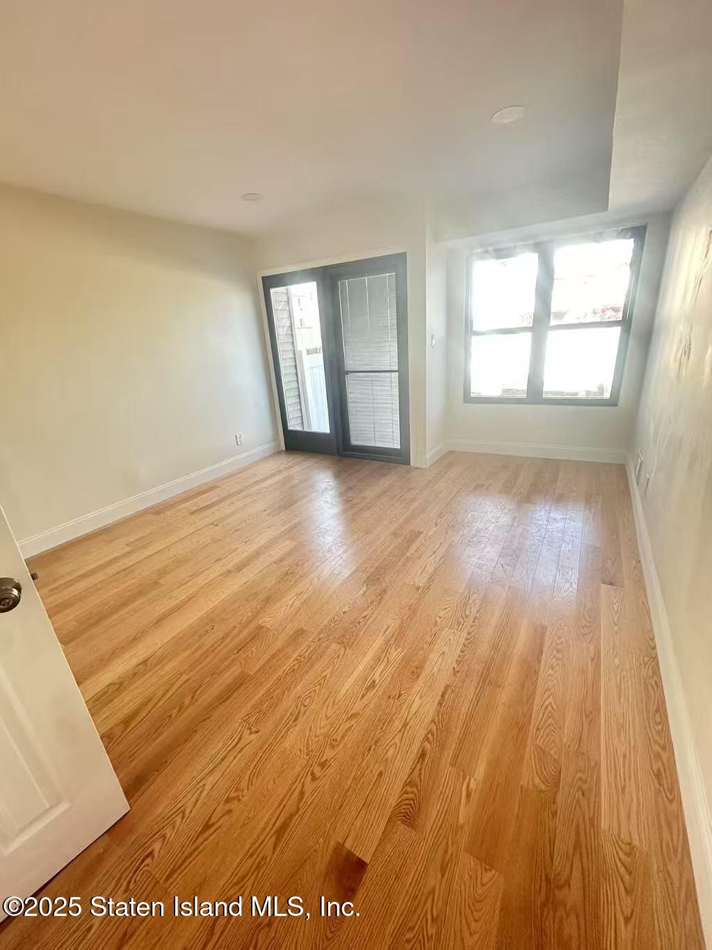 19 Drumgoole Road East Staten Island, NY 10312 - Photo 4 of 13 an empty room with wooden floor and windows
