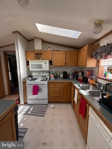 a kitchen with stainless steel appliances granite countertop a stove a sink dishwasher and a refrigerator