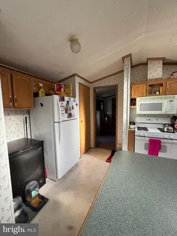 a kitchen with stainless steel appliances granite countertop a refrigerator and a stove