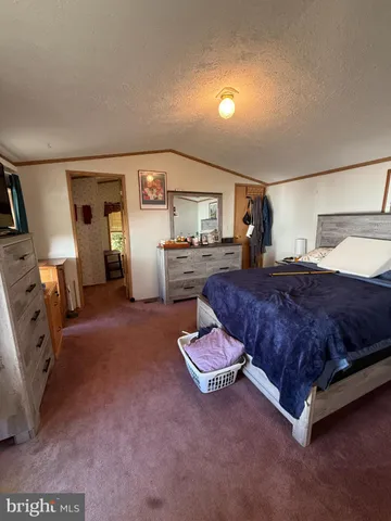 a spacious bedroom with a bed and wooden floor