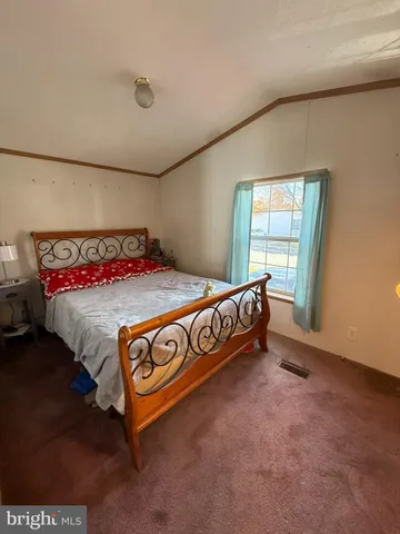 a bed sitting in a bedroom next to a window