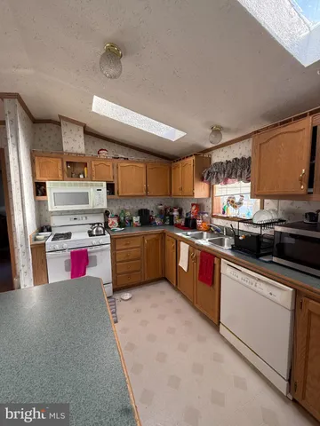 a kitchen with stainless steel appliances kitchen island granite countertop a stove sink and cabinets