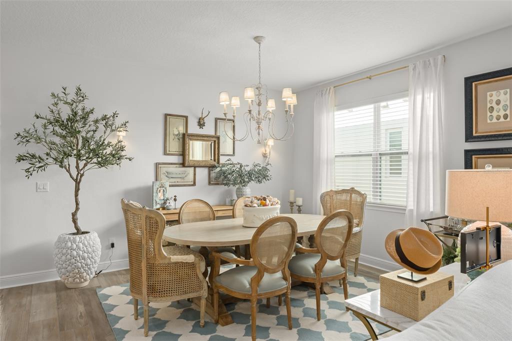 2983 Rapollo Lane Apopka, FL 32712 - Photo 16 of 62 a dining room with furniture a chandelier and wooden floor