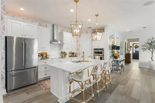 a kitchen with stainless steel appliances kitchen island granite countertop a sink and refrigerator
