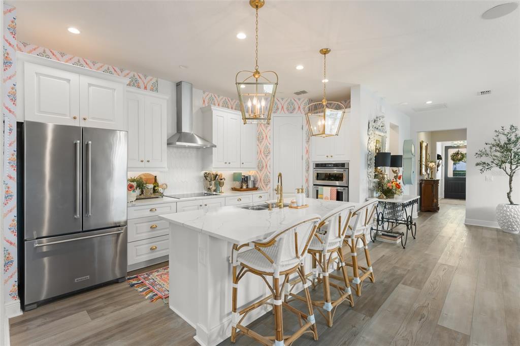 2983 Rapollo Lane Apopka, FL 32712 - Photo 23 of 62 a kitchen with stainless steel appliances a dining table chairs refrigerator and cabinets