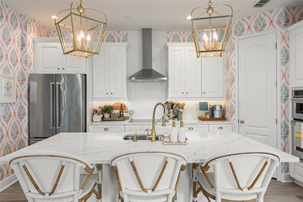 2983 Rapollo Lane Apopka, FL 32712 - Photo 24 of 62 a kitchen with stainless steel appliances granite countertop a table chairs and a refrigerator