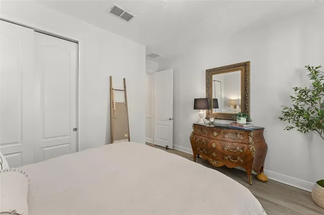 a bedroom with a bed a mirror and a window