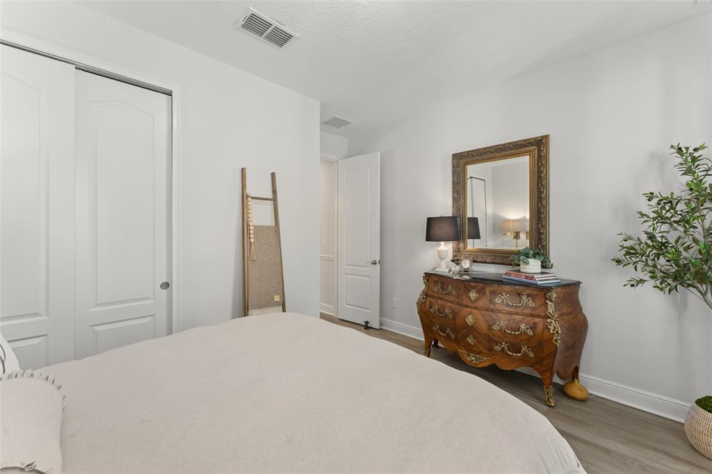 2983 Rapollo Lane Apopka, FL 32712 - Photo 9 of 62 a bedroom with a bed flat screen tv and a potted plant