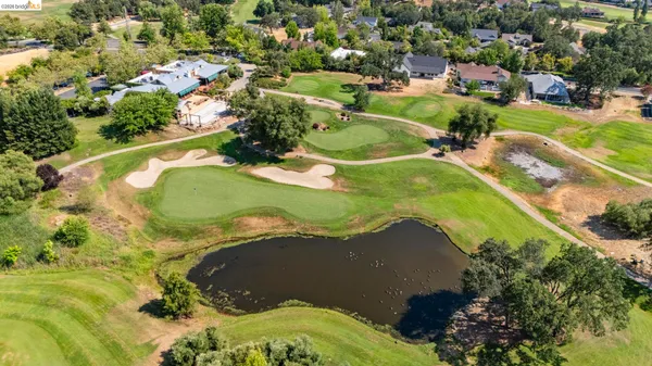 an aerial view of a house with a garden and lake view