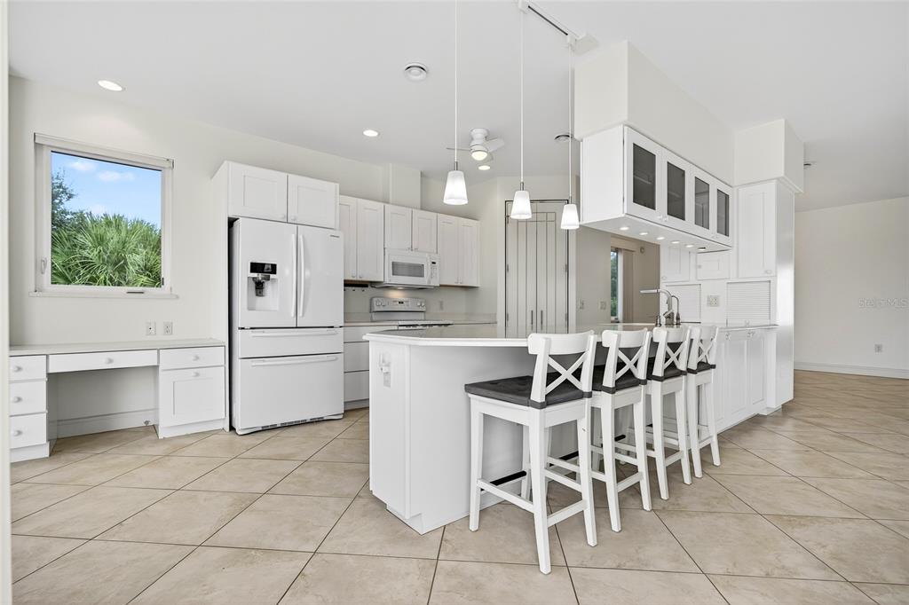 15435 Appleton Boulevard Port Charlotte, FL 33981 - Photo 12 of 49 a kitchen with stainless steel appliances kitchen island granite countertop a table chairs and a refrigerator