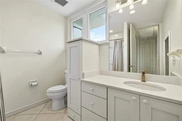 a bathroom with a granite countertop sink a toilet and shower