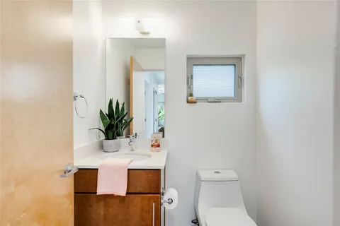 a bathroom with a toilet a sink and mirror