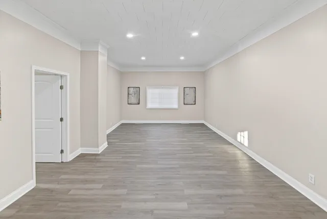 a view of an empty room with wooden floor
