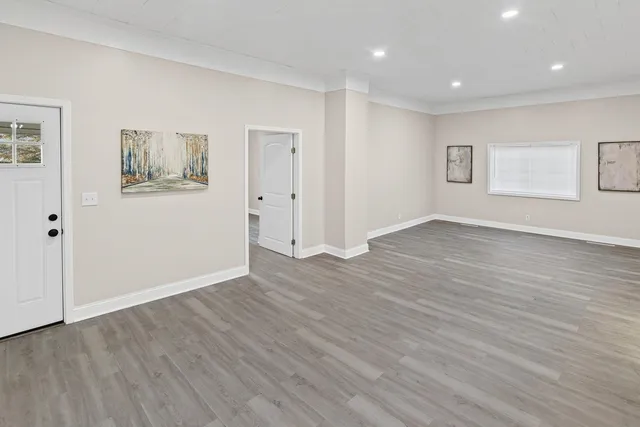 a view of an empty room with wooden floor