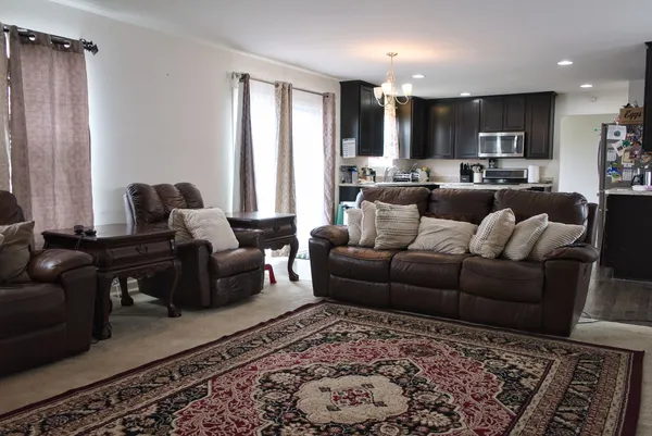 a living room with furniture and kitchen view