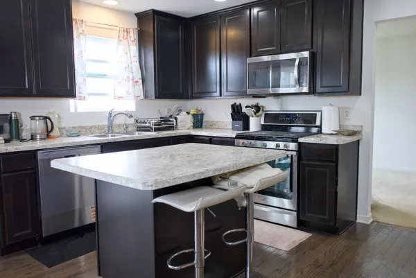 a kitchen with stainless steel appliances granite countertop a sink stove microwave and cabinets