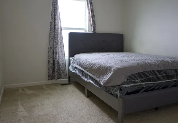 a bed sitting in a bedroom next to a window