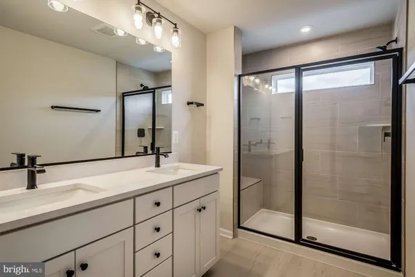 a bathroom with a shower sink and mirror