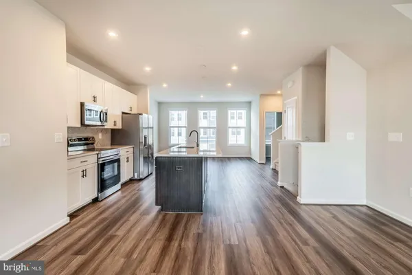 a kitchen with wooden floors and stainless steel appliances